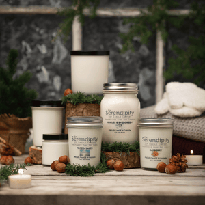 Collection of Serendipity candles on a wooden surface with decorative elements.