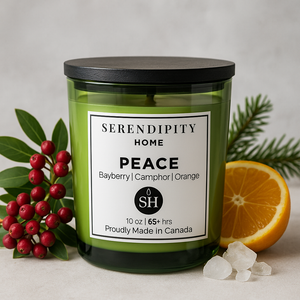 Scented candle labeled 'Peace' from Serendipity Home with bayberry, camphor and orange on a neutral background