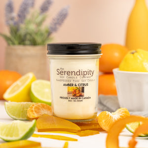 Serendipity Amber & CItrus candle with citrus fruits in the background