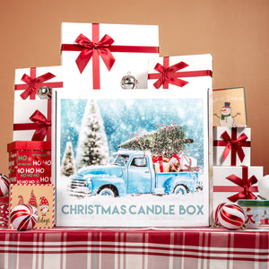 Christmas candle box with festive design featuring a truck and tree, surrounded by gift boxes and ornaments on a plaid tablecloth.