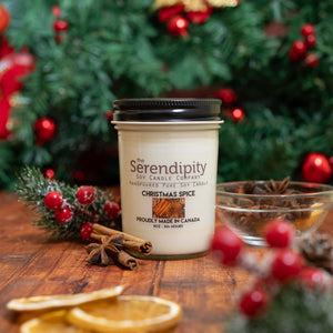 Serendipity candle with Christmas spices and decorations on a wooden surface